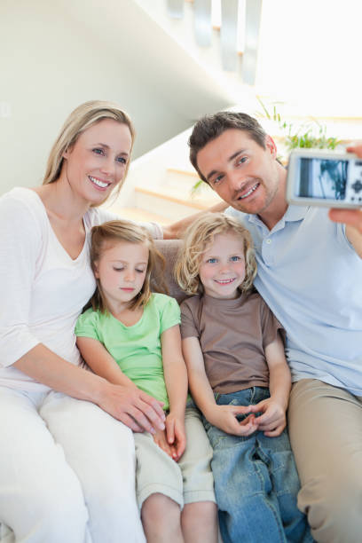 istock Man taking family picture on couch 828946644