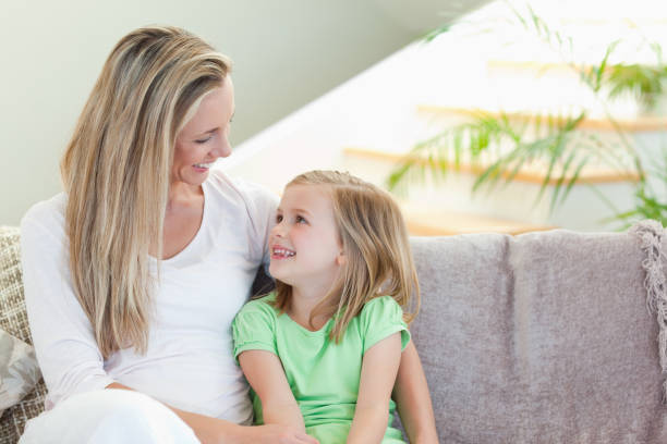 istock Mother and daughter sitting on sofa 828946774