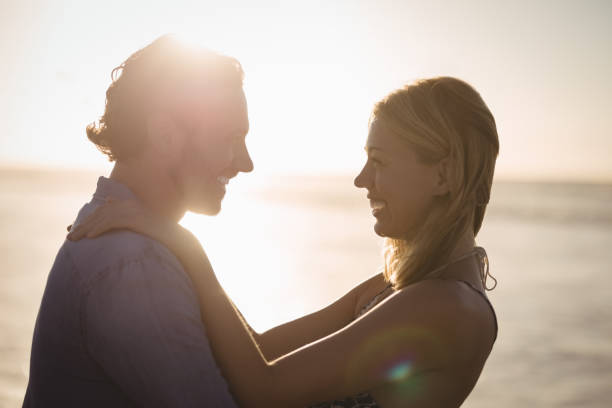 istock Happy young couple embracing at beach 828954562