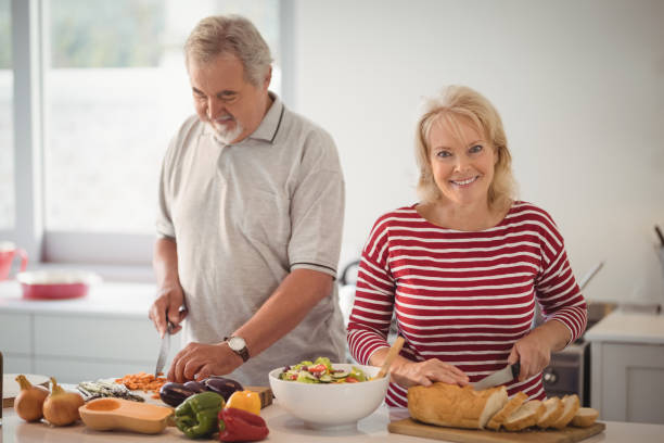 istock Smiling senior couple preparing food in kitchen 828973578
