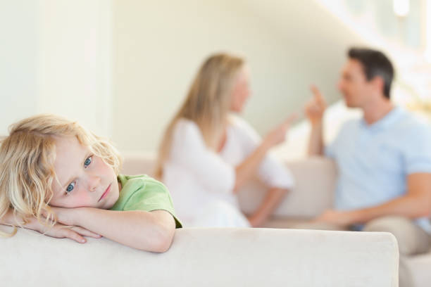 istock Sad boy with arguing parents behind him 828979298