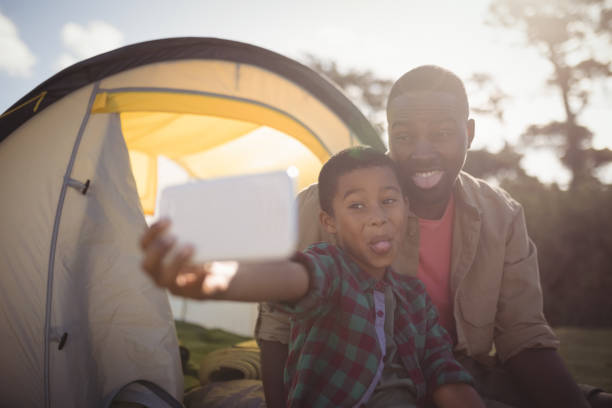 istock Father and son taking selfie with mobile phone in park 828980370