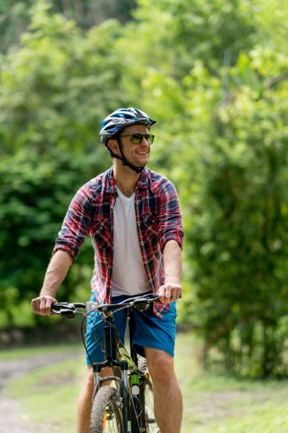 istock Casual man cycling outdoors and looking very happy 828991602