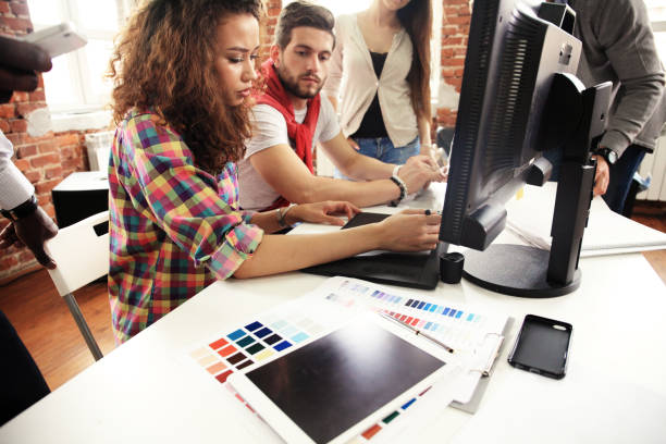 istock Teamwork concept.Young creative coworkers working with new startup project in modern office.Group of people analyze data on desktop computer 829005450
