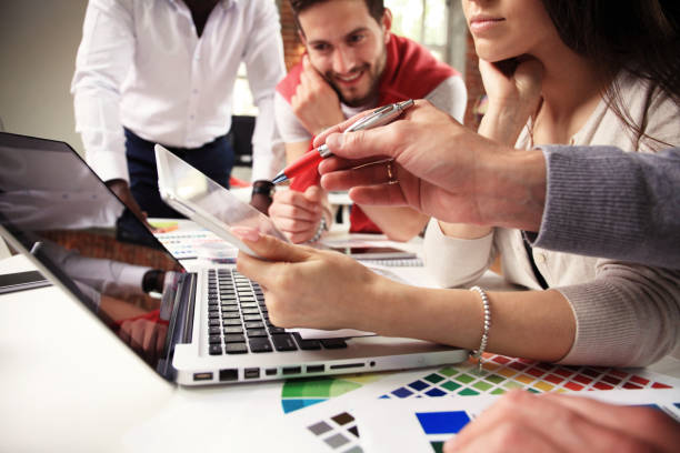 istock Teamwork concept.Young creative coworkers working with new startup project in modern office.Group of people analyze data on desktop computer 829005462
