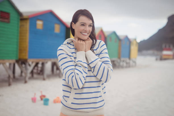 Smiling woman looking away while standing at beach