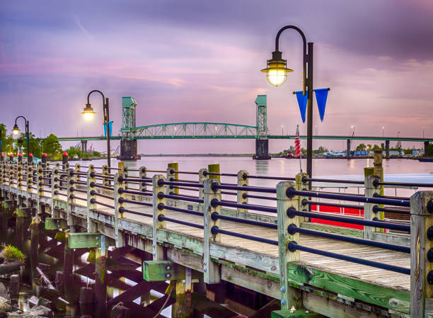 Riverwalk in Wilmington, North Carolina Riverwalk in Wilmington, North Carolina, USA at night with the Cape Fear Memorial Bridge. cape fear stock pictures, royalty-free photos & images