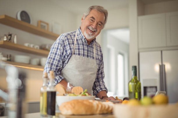 istock Senior man chopping vegetables at home 829038058