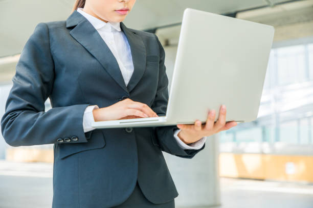 istock woman holding laptop in office building 829042140