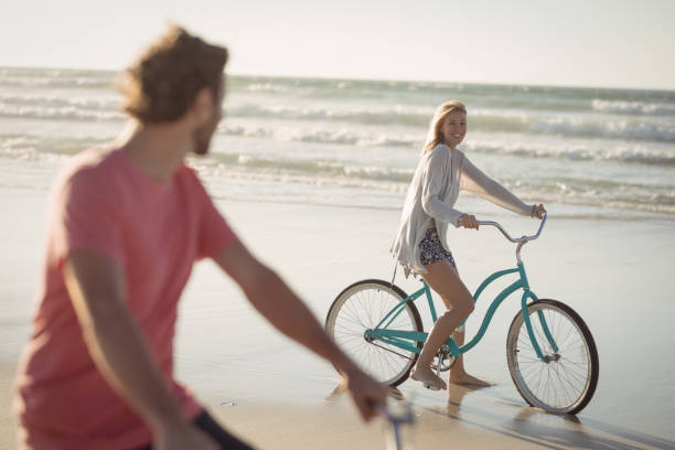 istock Couple riding bicycle at beach 829043952