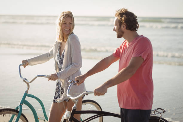 istock Happy young couple with bicycles at beach 829048918