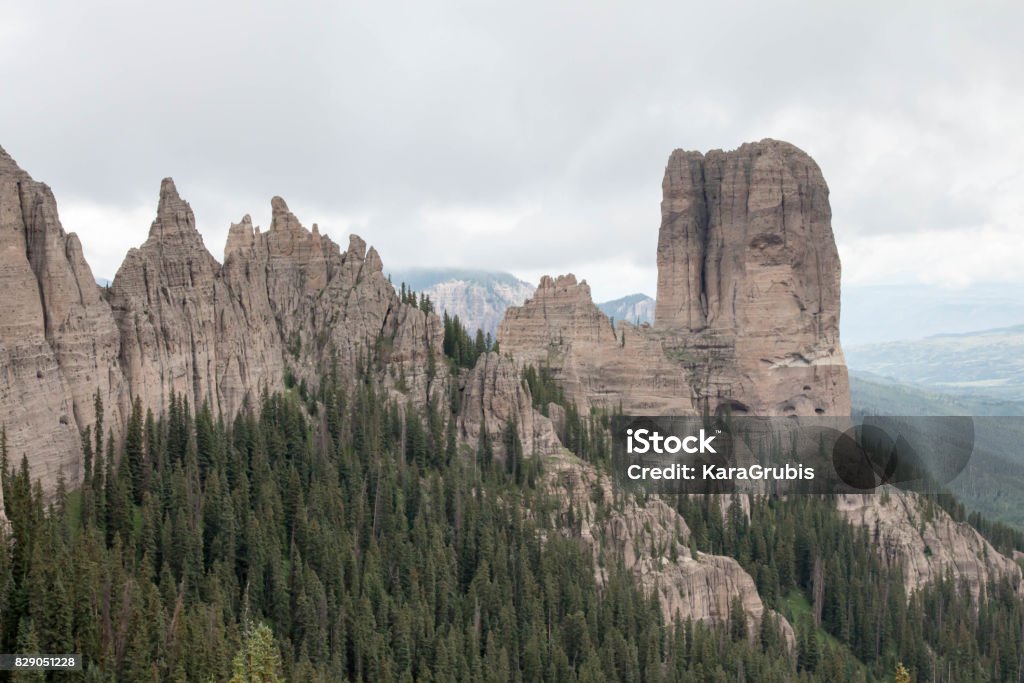 Chimney rock with jagged mountain range in the Uncompahgre National Forest A geological formation known as chimney rock in the Uncompahgre National Forest Beauty In Nature Stock Photo