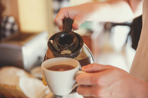istock Waiter pouring hot coffee into coffee cup 829068774