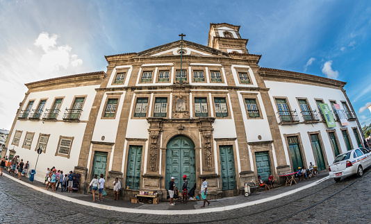 Salvador, Bahia, Brazil. 05th February 2017. People on the street in front of Mercy Museum (Museu da Misericordia) in Pelourinho area, Selling objects to passing by tourists. Imponent building facade of an old church transformed into a museum.