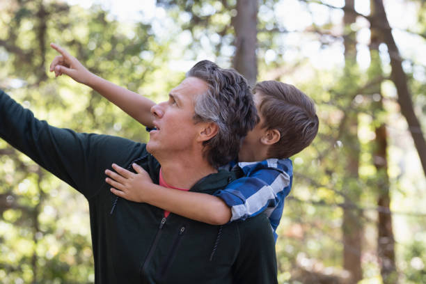 istock Father and son pointing away in forest 829106464