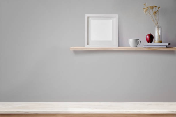 istock Empty marble table top and wood shelf with blank white frame and coffee. 829120942