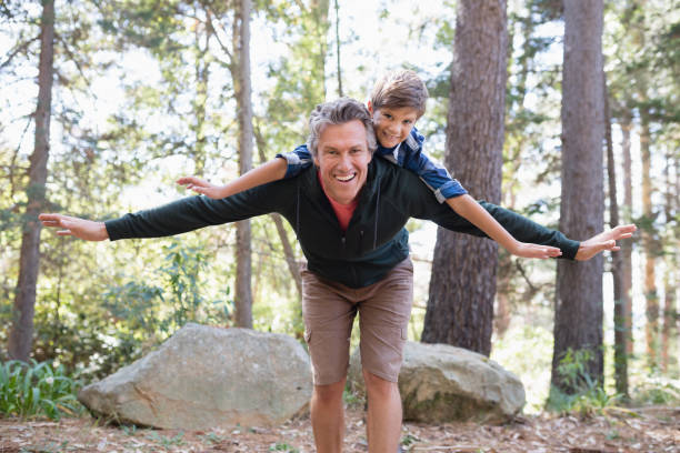 istock Cheerful father piggybacking son while hiking in forest 829131988