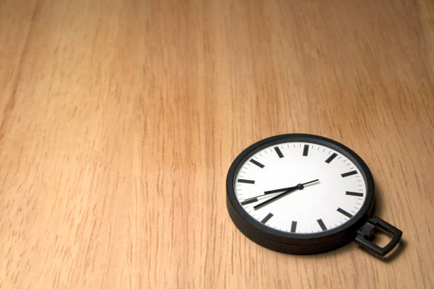 istock Pocket watch against a light wood background. 829139362