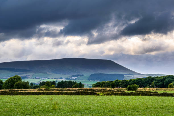 clouds over farms and pendle hill - pendle imagens e fotografias de stock