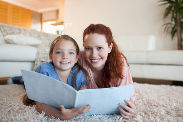 istock Mother and daughter looking at periodical 829169816