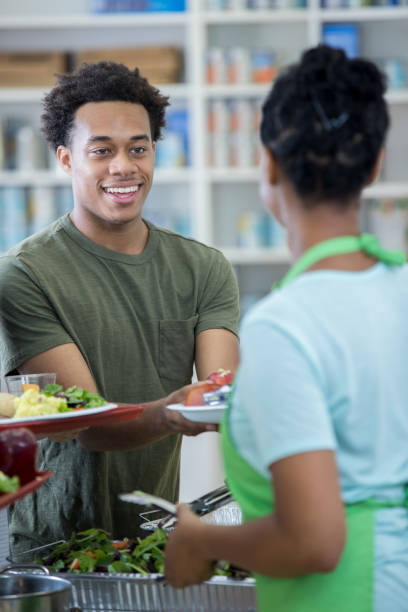 istock Young man receives a hot meal in soup kitchen 829171128