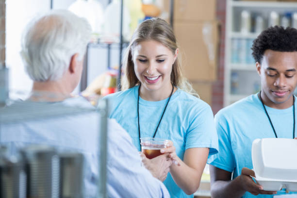 istock Female volunteer hands man iced tea in soup kitchen 829171204