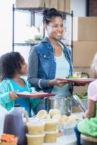 istock Mom and daughter receive a meal in soup kitchen 829171248
