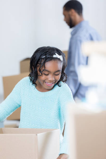 istock Little girl looks for things to pack in a moving box 829171806