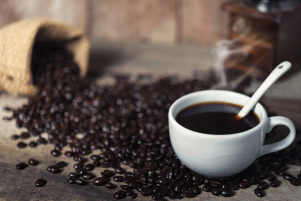 istock Cup of coffee and coffee beans on table 829178838