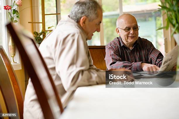 Reading The Morning Paper Stock Photo - Download Image Now - 55-59 Years, Adults Only, Brother