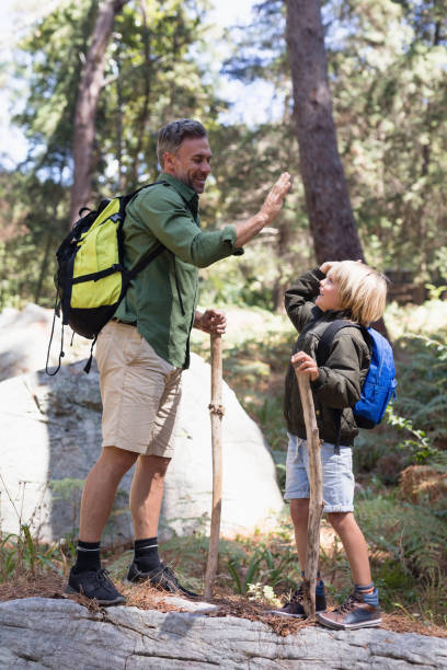istock Father and son giving high five while hiking in forest 829197978