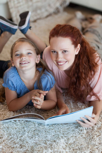 istock Mother and daughter on the floor reading 829206020