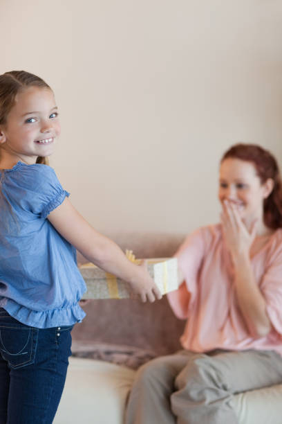 istock Little girl giving her mother a present 829206652