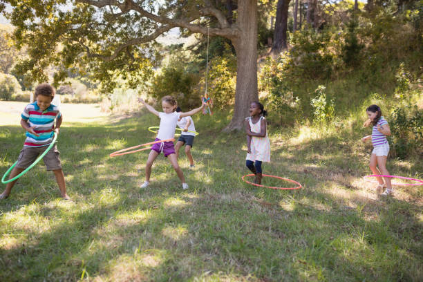 istock Group of friends playing with hula hoops at campsite 829217768