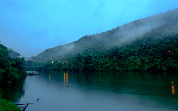 forêt de montagne avec le brouillard et la péniche sur le paysage de la rivière kwai sur pluie à kanchanaburi, thaïlande. concept naturel - erawan national park beauty in nature waterfall photos et images de collection