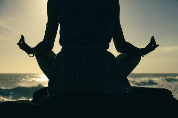 istock Woman practicing yoga on the beach. 829239094