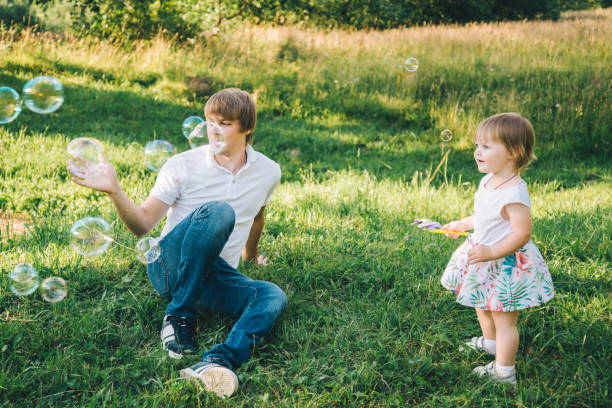 istock father plays with his daughter with soapbubble 829244600