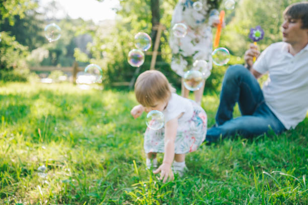 istock father and mother play with his daughter with soapbubble 829246136