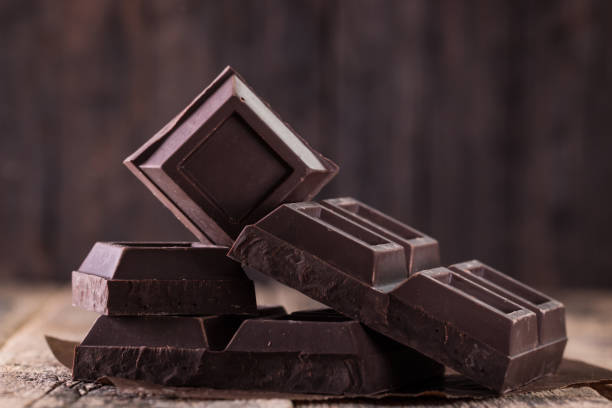 pila de chocolate oscuro, sobre fondo de concepto de mesa, chocolate - brown chocolate candy bar close up fotografías e imágenes de stock