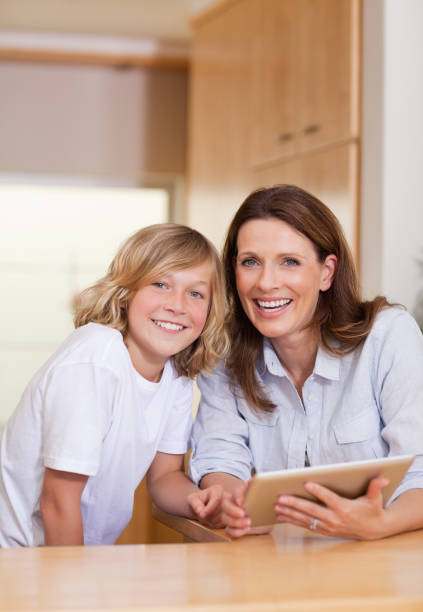 istock Woman and her son using tablet in the kitchen 829266150