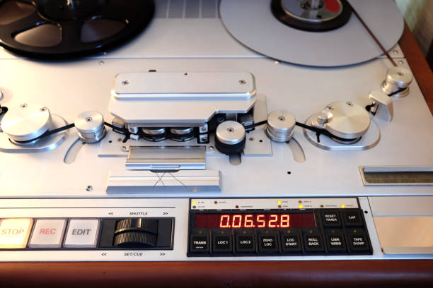 istock Modern studio stereo tape recorder with magnetic tape front view closeup 829273794