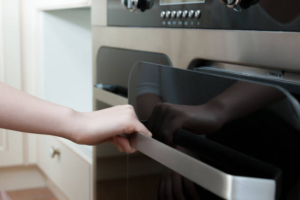 istock hand open door of oven in modern kitchen 829300456