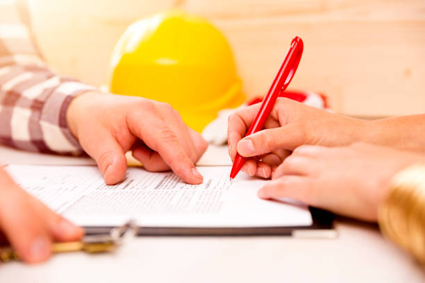 Woman signing construction contract with contractor to build a house stock photo