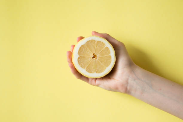 istock Lemon in woman's hand on a yellow background 829308288