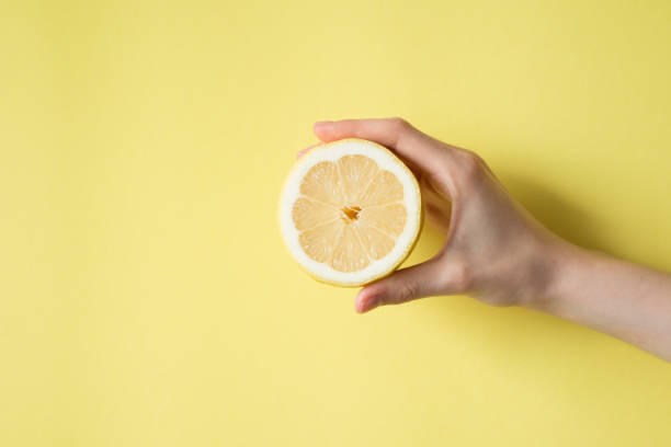 istock Lemon in woman's hand on a yellow background 829308470