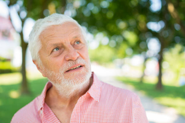 istock Portrait of senior with white beard and blurred  park background 829317042
