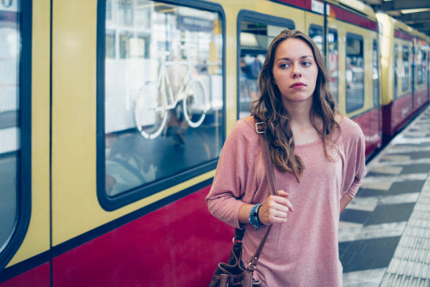istock young woman, commuter at platform leaves a train 829325068