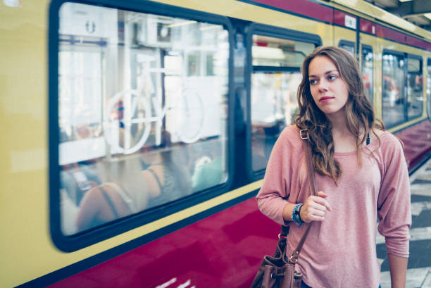 istock young woman, commuter at platform enters a train 829325094