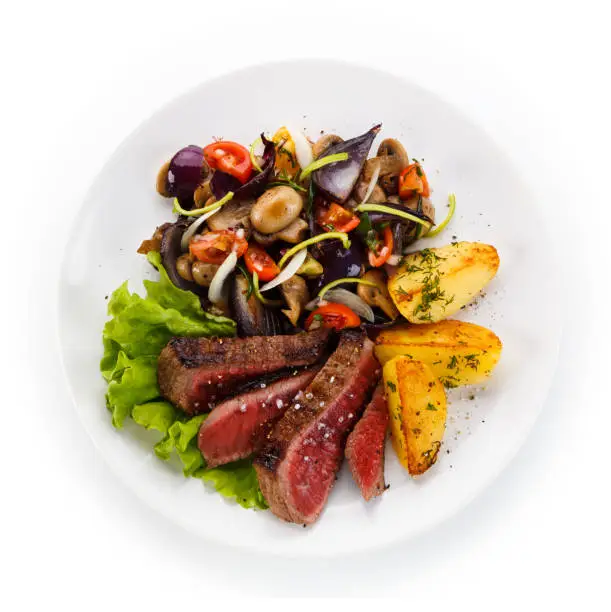 Grilled beefsteak with baked potatoes on white background