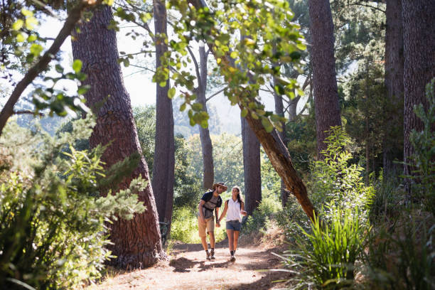 istock Hikers holding hands on trail in forest 829360182